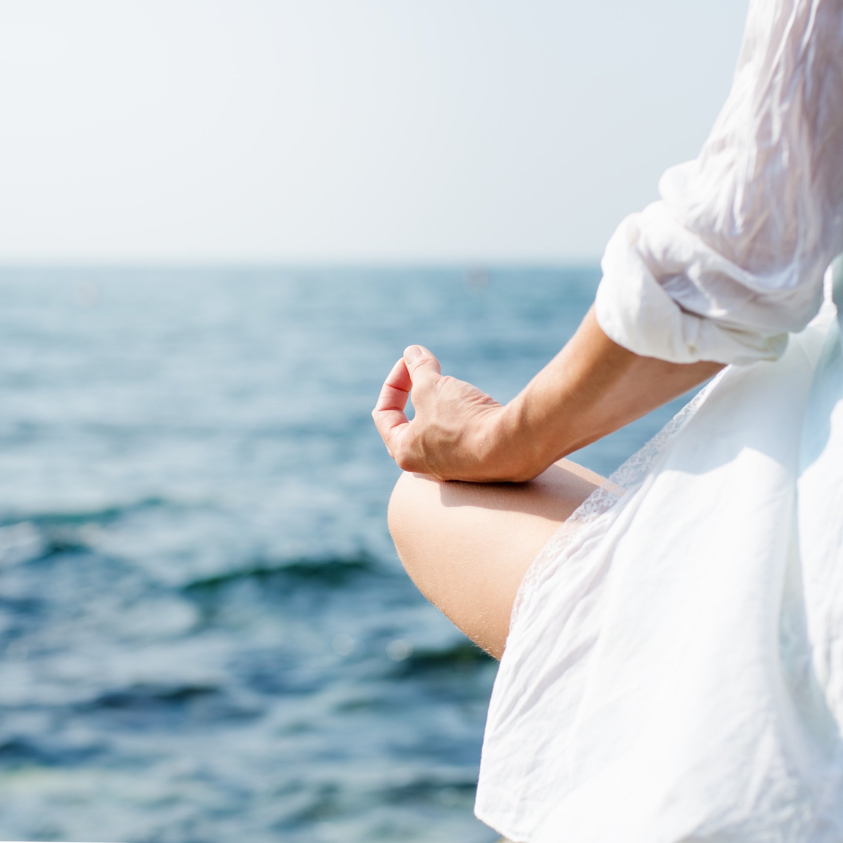 Woman meditating at the sea